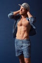 Hes a style individual. A muscular young man with an open shirt and unique fashion sense looking away. Royalty Free Stock Photo