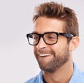 Hes such a goofball. Studio shot of a young man making a nerdy face against a gray background.