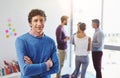 Hes thriving in this job. Portrait of a businessman with his colleagues standing in the background. Royalty Free Stock Photo