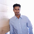 Hes the ultimate businessman. Portrait of a handsome young businessman leaning against a wooden wall.