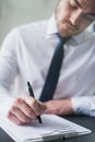 Hes well prepared for this questionnaire. a young businessman filling out paperwork on a clipboard while sitting at a Royalty Free Stock Photo