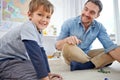 Hes the worlds best dad. Portrait of a happy father and son playing marbles together at home. Royalty Free Stock Photo