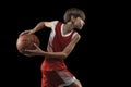 Cropped portrait of teen boy playing basketball isolated over black background Royalty Free Stock Photo