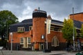 Orange brick building with dark gray roof slates called `het Schip` with