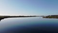 Backlight drone footage of the tidal river Het Spui in Holland with calm and clear weather.