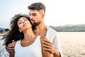 Heterosexual mixed race couple in romance scene at sunset with vintage photo effect filter - Handsome Caucasian guy embracing from