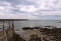 Heugh breakwater pier from shore in stormy, cloudy weather seascape