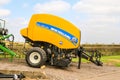 A round baler for making hay bales bales during harvesting Royalty Free Stock Photo