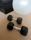 Hex dumbbell weights, fitness ball and storage ottoman in living room.