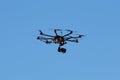 Hexacopter drone with camera in action on blue sky