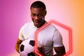 Hexagon neon over african american fan cheering with france flag on cheek during soccer match Royalty Free Stock Photo