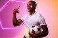 Hexagon neon over happy african american fan cheering with france flag on cheek during soccer match Royalty Free Stock Photo