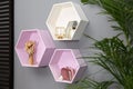 Hexagon shaped shelves with different stuff on wall. Interior design