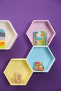 Hexagon shaped shelves with toys on wall. Interior design