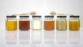 Hexagonal jars with different types and colors of fresh flower honey and a honey spoon. vitamin food for health and life