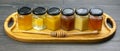 Hexagonal jars with different types and colors of fresh flower honey and a honey spoon. vitamin food for health and life