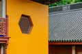 Hexagonal window on yellow wall with black roof in Lingyin Temple, Hangzhou, China Royalty Free Stock Photo