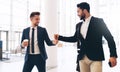 Hey buddy. Cropped shot of two handsome young businessmen greeting each other while in the office during the day. Royalty Free Stock Photo