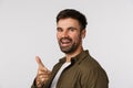 Hey it was nice talking you. Cheerful, handsome bearded modern guy standing profile, turn camera and smiling, pointing Royalty Free Stock Photo
