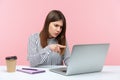 Hey you! Angry business woman in striped shirt pointing to laptop screen, scolding and accusing talking on video call, having Royalty Free Stock Photo