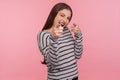 Hey, you are awesome! Portrait of playful happy young woman in striped sweatshirt pointing fingers