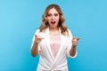 Hey, you are awesome! Portrait of pleasantly surprised woman pointing at camera with shocked face. blue background