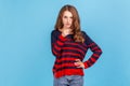 Hey you, be careful. Portrait of young woman wearing striped casual style sweater seriously pointing