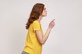 Hey you, be careful. Side view of strict bossy woman of young age with brown hair in yellow casual T