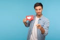 Hey you, click Like! Portrait of handsome blogger man in denim shirt holding social media heart Like button