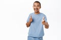 Hey you good job. Enthusiastic smiling guy pointing fingers at camera, standing in blue tshirt over white background Royalty Free Stock Photo