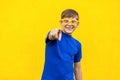 Hey you!Happiness freckled boy in yellow glasses, pointing finger and looking at camera. Royalty Free Stock Photo