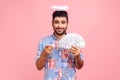 Hey you, make money. Portrait of positive angelic bearded man with halo over head in blue shirt Royalty Free Stock Photo