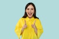 Playful happy beautiful young hispanic woman in casual yellow outwear pointing at you and smiling Royalty Free Stock Photo
