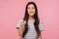 Hey you! Portrait of cheerful girl with long brunette hair in striped t-shirt pointing to camera and smiling Royalty Free Stock Photo