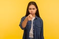 Hey you! Portrait of strict bossy angry girl in denim shirt pointing finger to camera, teaching and scolding