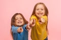 Hey you! Two charming happy little girls pointing to camera, indicating lucky one and smiling