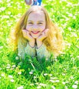 Heyday concept. Girl on smiling face spend leisure outdoors. Girl lying on grass at grassplot, green background. Child