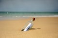 Hi! Bottle with greetings on beach. Message in a bottle Royalty Free Stock Photo