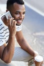 Hi, its me...A handsome casually dressed african american businessman sitting in the city and using his mobile while Royalty Free Stock Photo