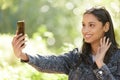 Hi mom, I made it. a young woman using her cellphone for a video call outside. Royalty Free Stock Photo