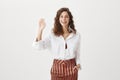 Hi what is up. Portrait of carefree friendly european female entrepreneur, holding hand in pocket and smiling broadly