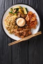 Hibachi dish consisting of fried rice with egg, shrimp, steak and vegetables served with sauce closeup in a plate. Vertical top Royalty Free Stock Photo