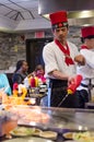 Hibachi restaurant chef preparing meal and entertaining guests