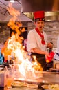 Hibachi restaurant chef preparing meal and entertaining guests