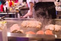 Hibachi restaurant chef preparing meal and entertaining guests