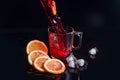 Hibiscus cold tea pouring into glass with ice, lemon and mint isolated on black background Royalty Free Stock Photo