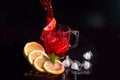 Hibiscus cold tea pouring into glass with ice, lemon and mint isolated on black background Royalty Free Stock Photo