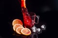 Hibiscus cold tea pouring into glass with ice, lemon and mint isolated on black background Royalty Free Stock Photo