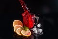 Hibiscus cold tea pouring into glass with ice, lemon and mint isolated on black background Royalty Free Stock Photo