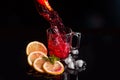 Hibiscus cold tea pouring into glass with ice, lemon and mint isolated on black background Royalty Free Stock Photo